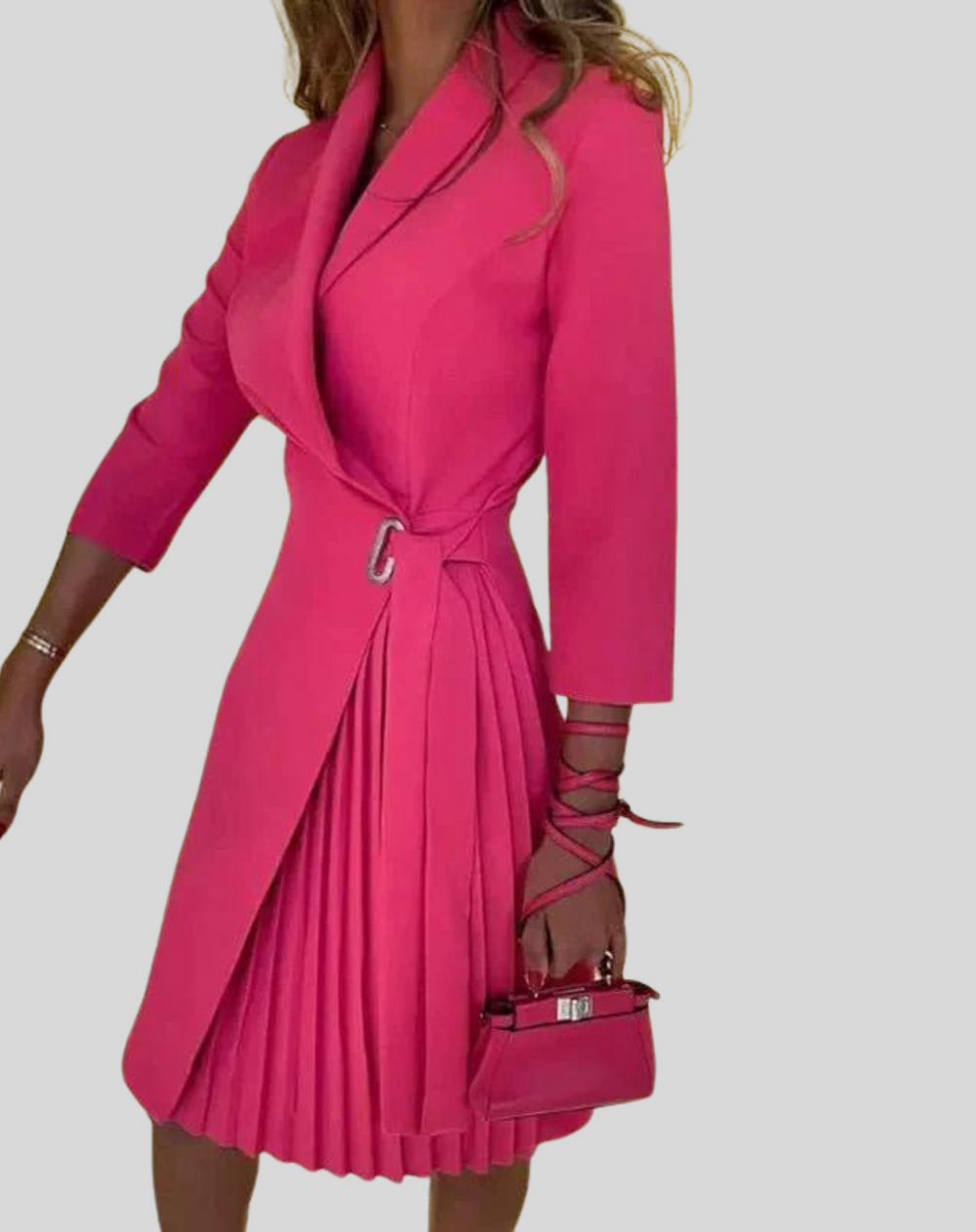 Akini is een elegante knielange blazerjurk met een stijlvolle knoopsluiting en een vrouwelijke plissé rok. Gemaakt van hoogwaardig polyester voor een flatterende pasvorm en ultiem comfort. Perfect voor werk, avondjes uit of formele gelegenheden. Verkrijgbaar in abrikoos, oranje, roze, zwart, stippen en meer, maten S-2XL. Upgrade je garderobe met Akini en straal verfijning en klasse uit. Bestel nu en maak een stijlvolle indruk bij elke gelegenheid!