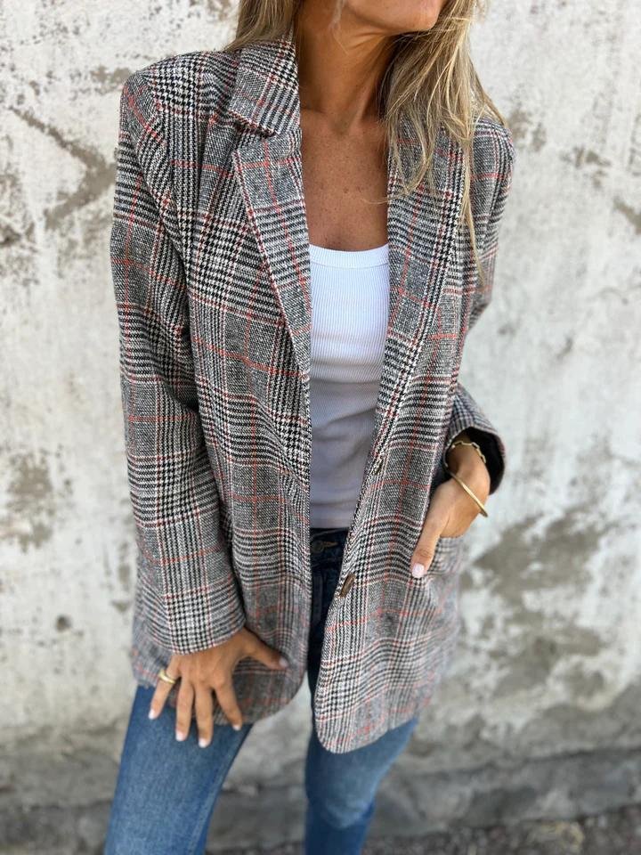 Swanet geruite blazer voor dames biedt warmte, comfort en tijdloze stijl. Gemaakt van een dikke katoen-polyestermix voor uitstekende isolatie tijdens koude dagen. Het klassieke geruite patroon en de getailleerde pasvorm zorgen voor een elegante look, ideaal voor zowel zakelijke als casual gelegenheden. Deze veelzijdige blazer combineert moeiteloos met elke outfit en is perfect voor het najaar en de winter. Een must-have voor een stijlvolle en verzorgde uitstraling.