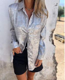vrouw in glamoureuze metallic blouse met borstzak en lange mouwen