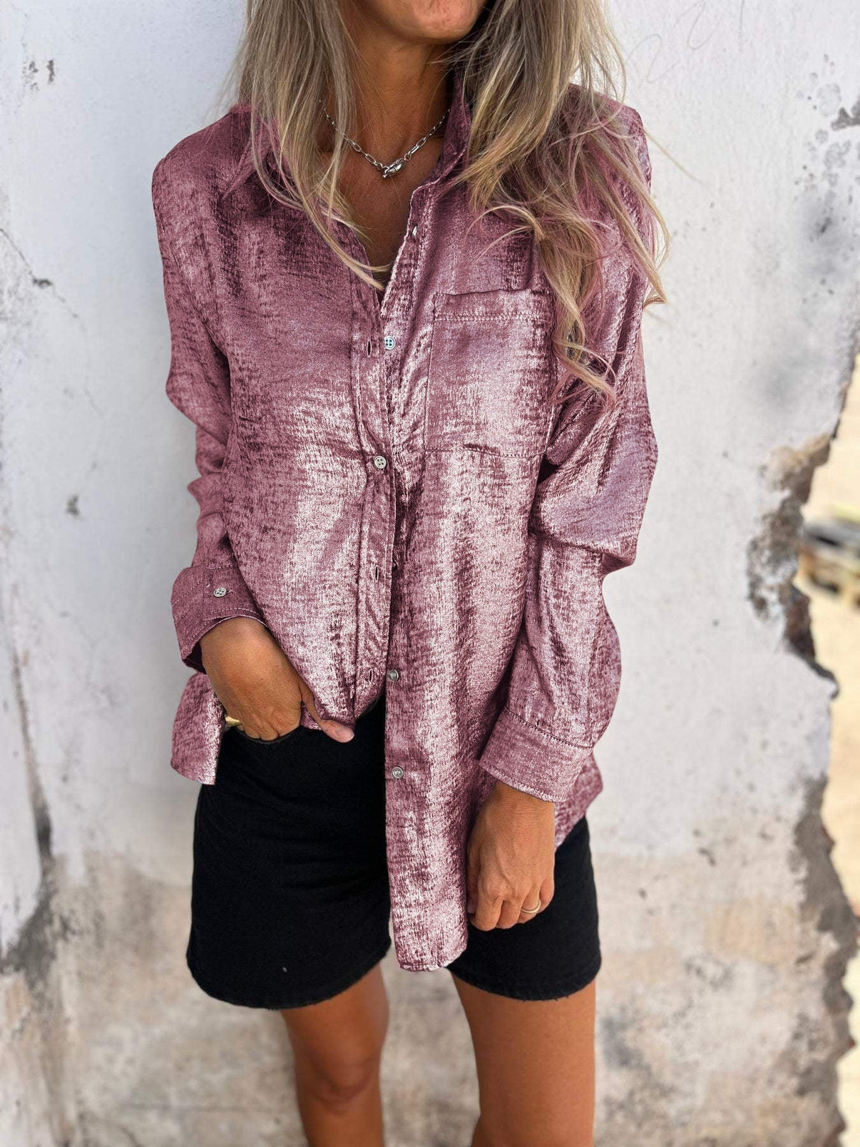 vrouw in glamoureuze metallic blouse met borstzak en lange mouwen