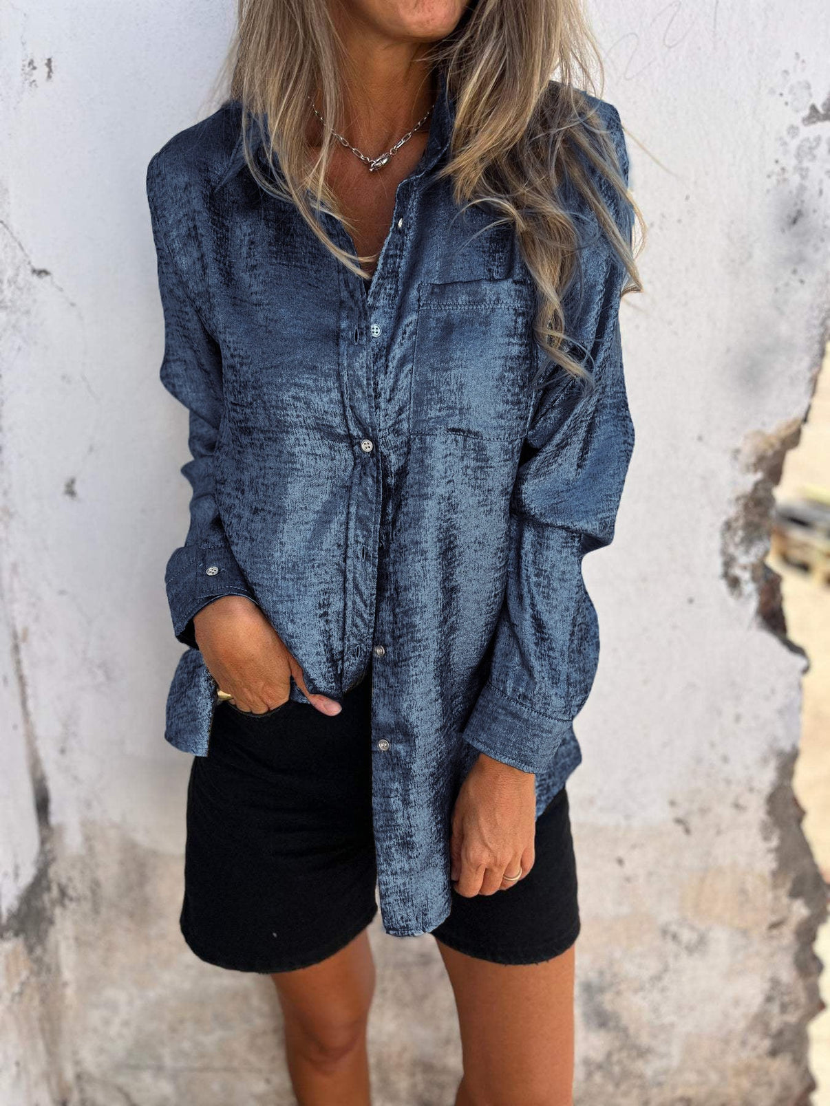 vrouw in glamoureuze metallic blouse met borstzak en lange mouwen