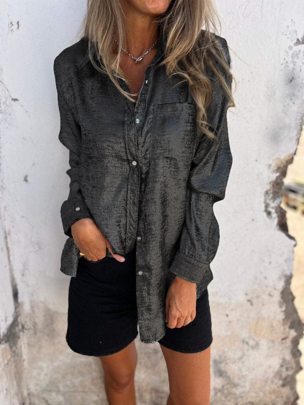 vrouw in glamoureuze metallic blouse met borstzak en lange mouwen