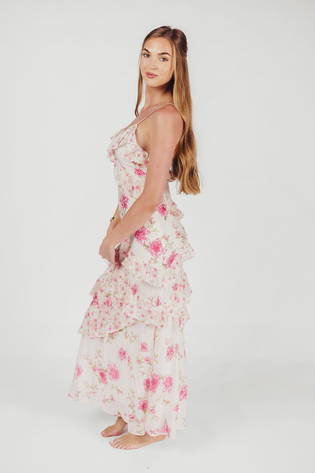 vrouw in ivoor roze maxi jurk met bloemen en ruches met open rug en spaghetti bandjes