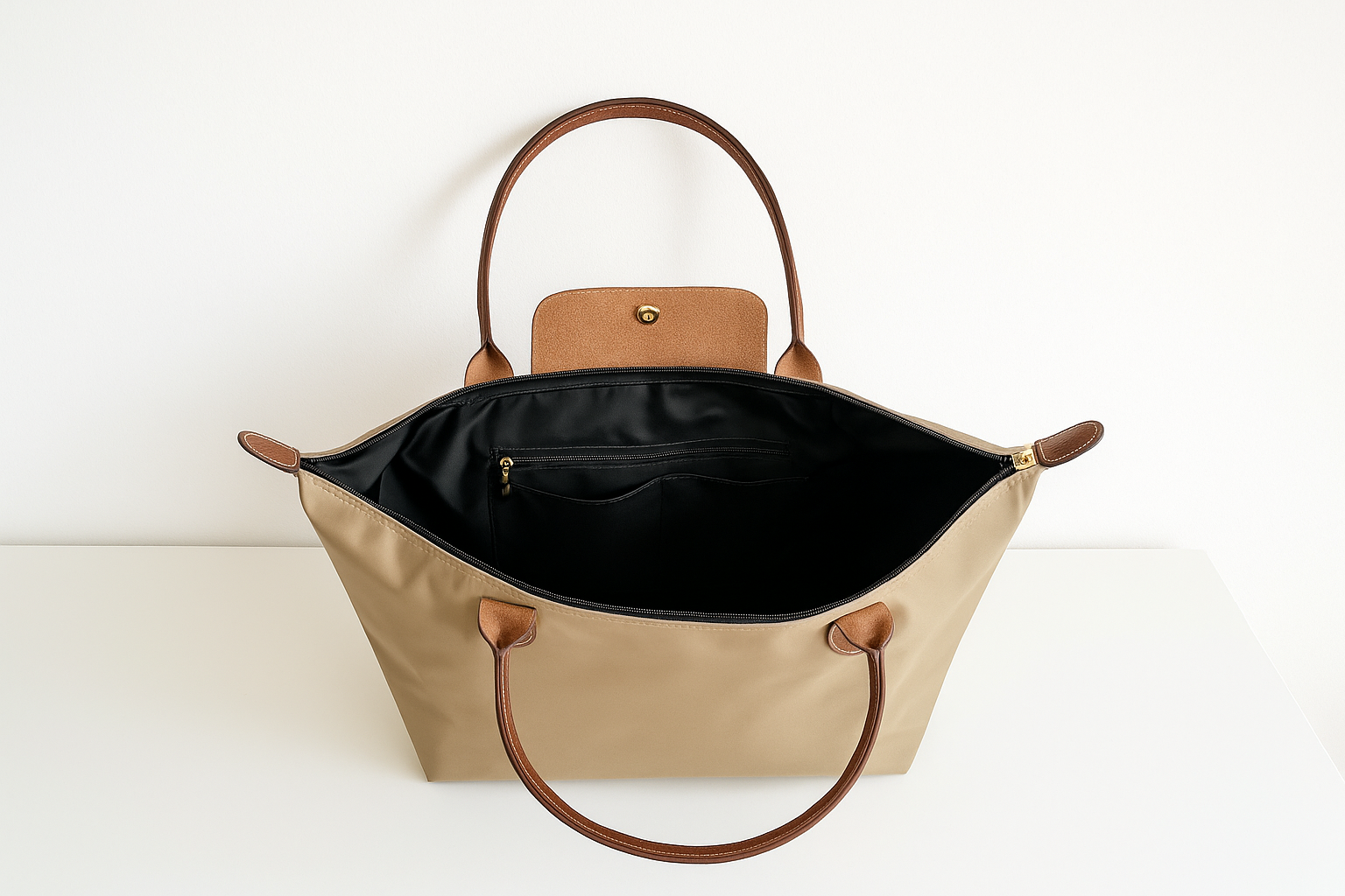 Binnenkant van beige nylon schoudertas voor dames met bruine leren details, ruime binnenkant en goudkleurige sluiting – waterafstotende, stijlvolle tas voor werk, reizen of dagelijks gebruik.