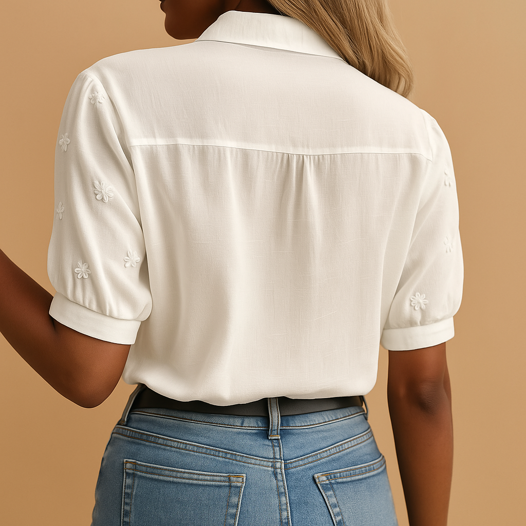 vrouw in trendy witte blouse met bloemen motief