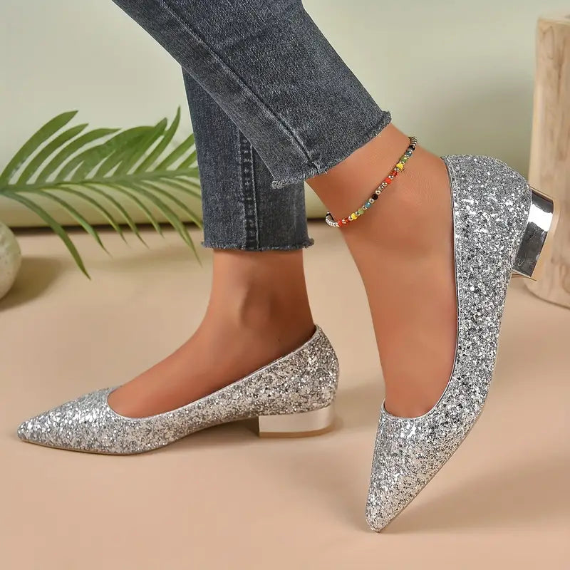 Elegante glitter ballerina's met spitse neus, perfect voor feestjes en speciale gelegenheden. De Saphira biedt een comfortabele pasvorm met een glamoureuze afwerking in goud en zilver. Ideaal om stijl en sprankeling toe te voegen aan elke outfit. Verkrijgbaar in maten 35-42. Bestel nu en ervaar de perfecte combinatie van comfort en verfijning met deze stijlvolle schoenen!