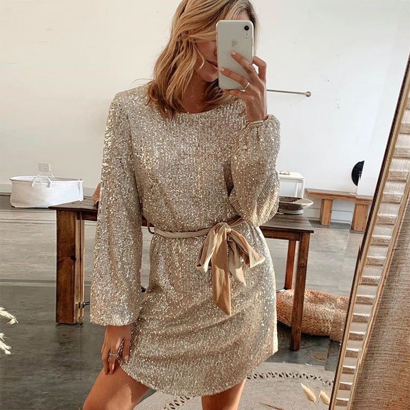 Zahra glitter feestjurk – een stralende en elegante keuze voor feestdagen en speciale gelegenheden. Met een glanzende gouden afwerking, lange mouwen en een verstelbare tailleband voor een flatterende pasvorm. Gemaakt van sprankelende stof die je laat schitteren. Verkrijgbaar in goud, in maten S-XL. Perfect voor een glamoureuze uitstraling. Bestel nu en straal op elk feest!